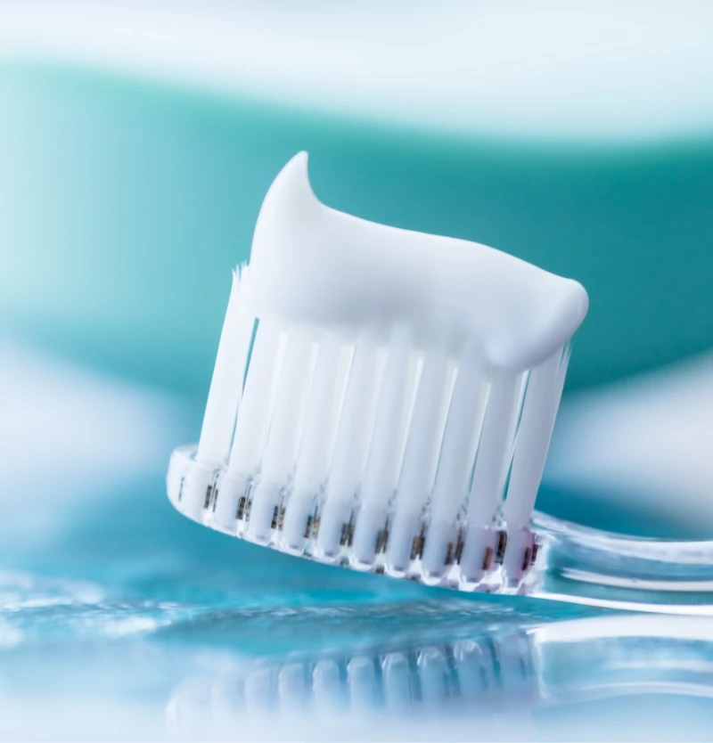 close up of toothbrush head with toothpaste on it