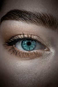 close up of a person looking at you with one blue eye